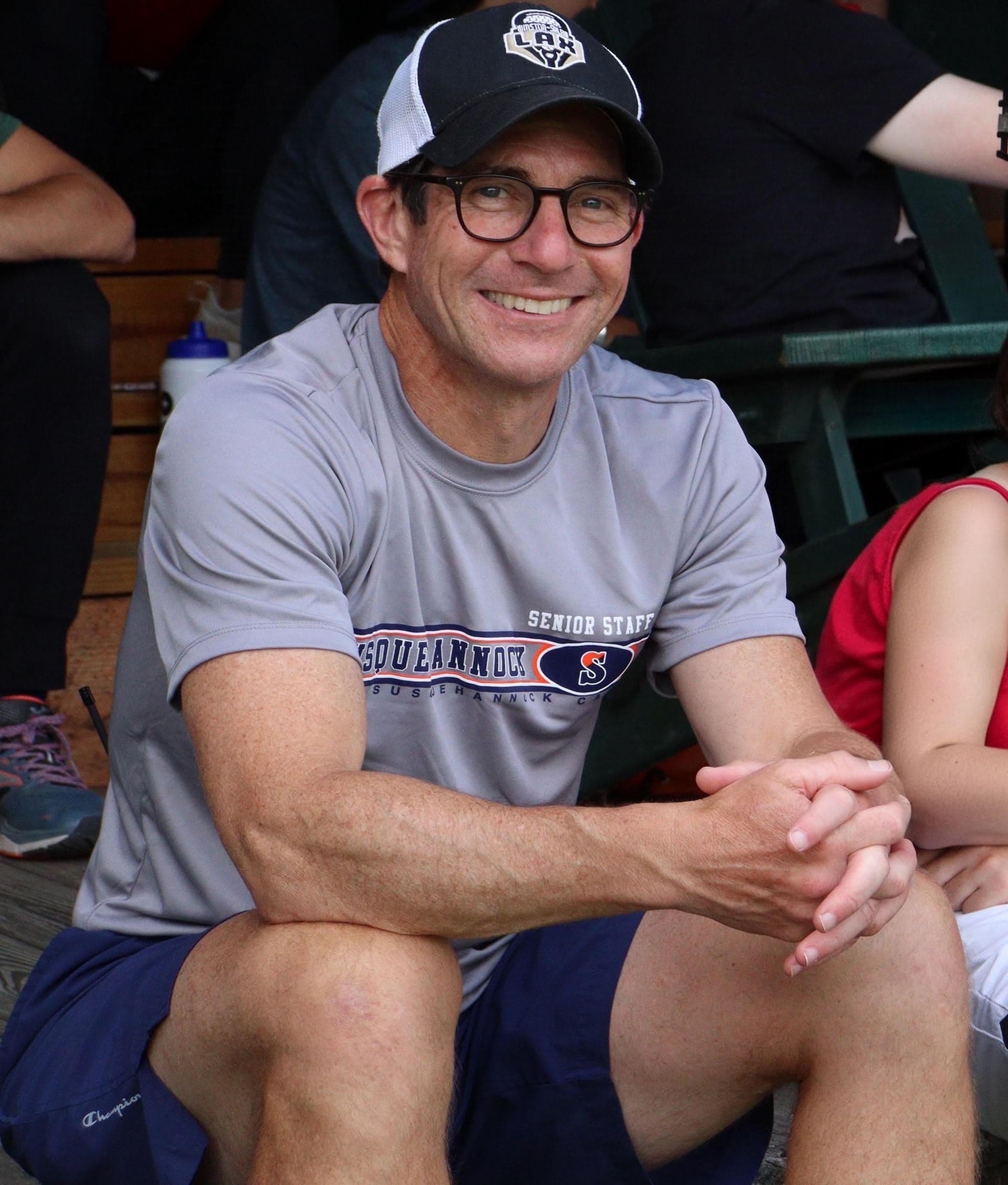 Andrew Hano, smiling, in a Susquehannock senior staff shirt and a ball cap