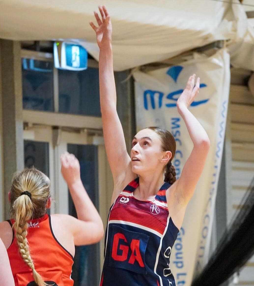 Caitlyn Beckett shooting during a netball match