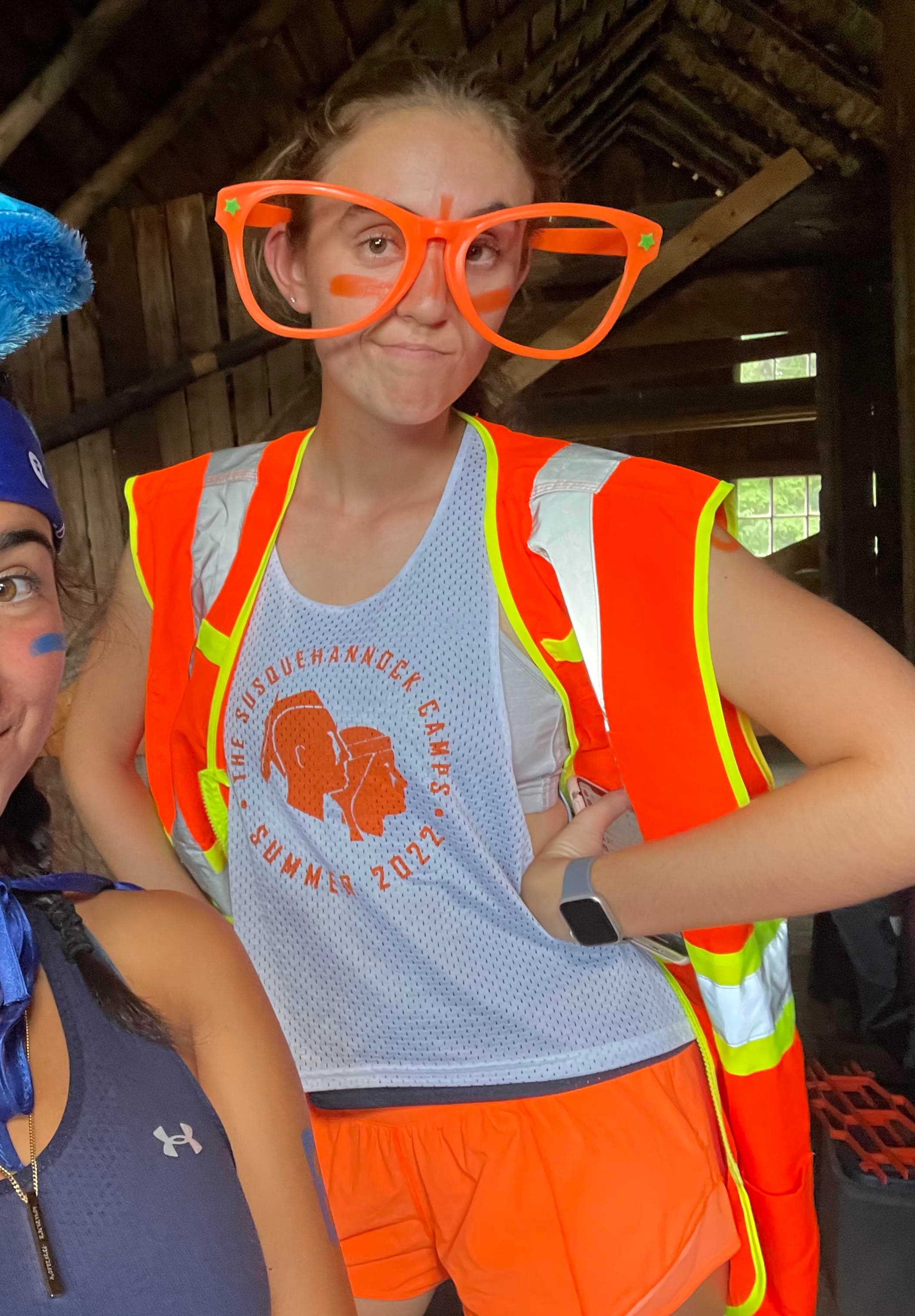 Caitlyn Beckett at camp in a Susquehannock pinnie and oversized novelty glasses