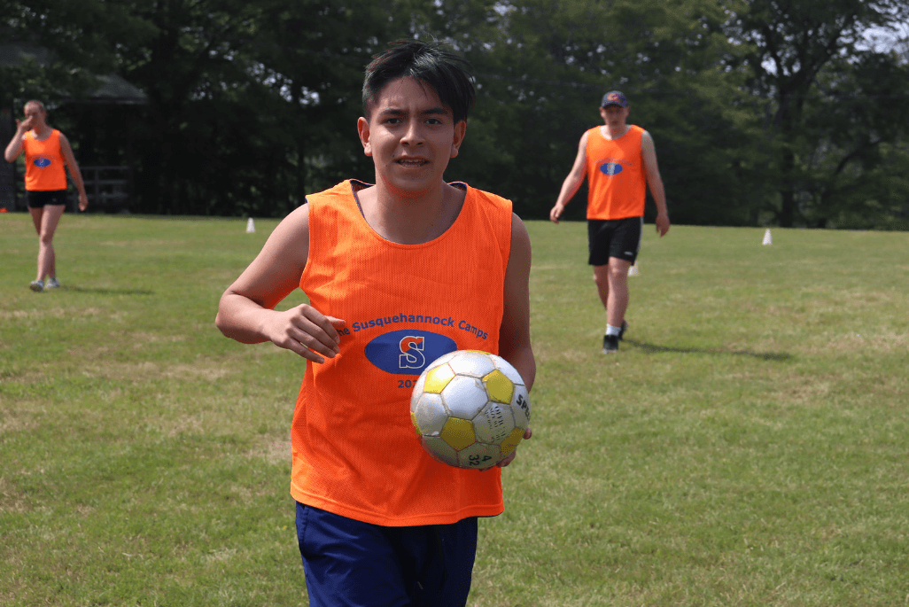 Manny Pinzón, a little older, with a soccer ball on the field at camp